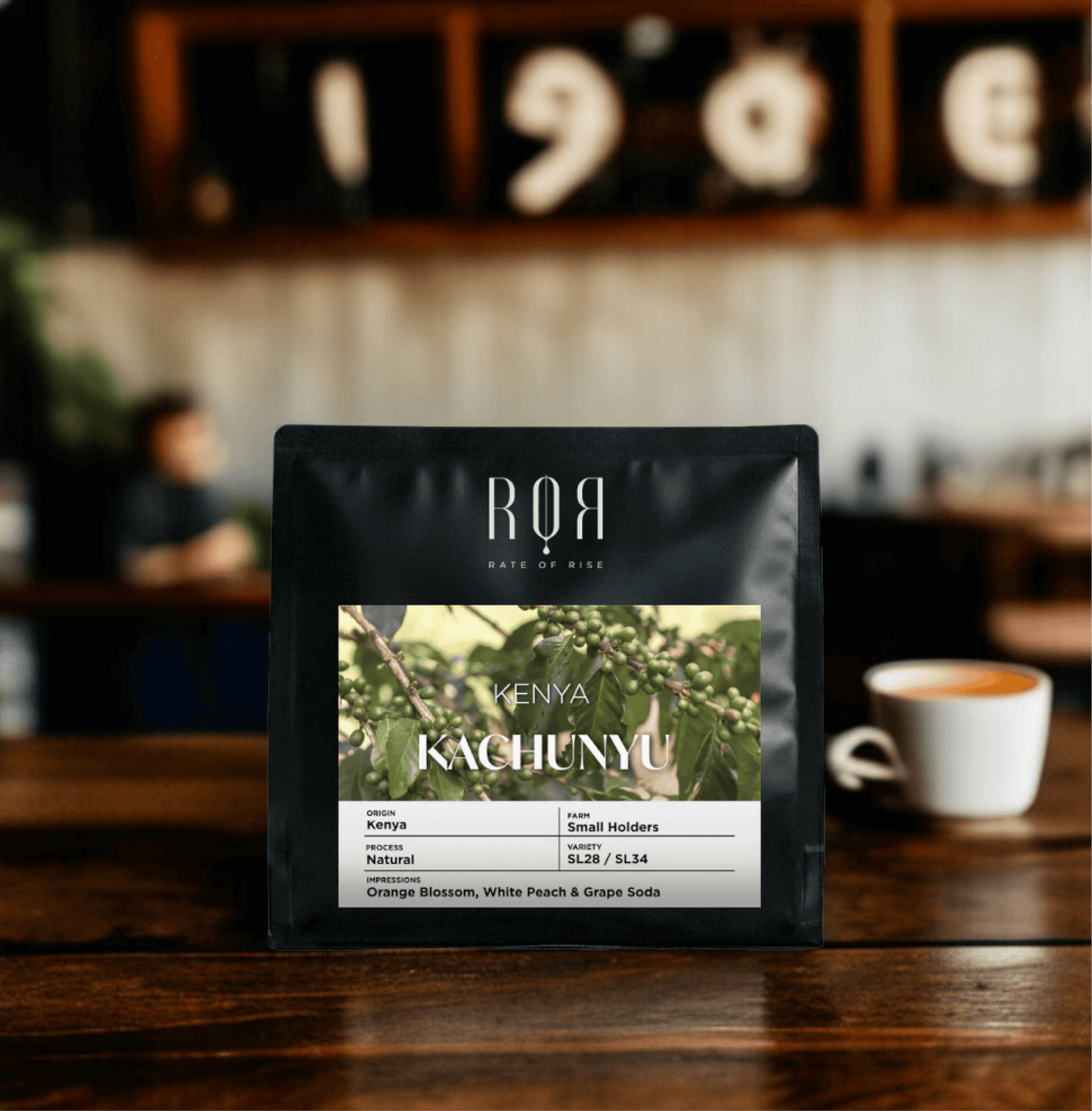 Kenya Kachunyu coffee bag on a cafe table, showcasing its vibrant and complex East African flavors.