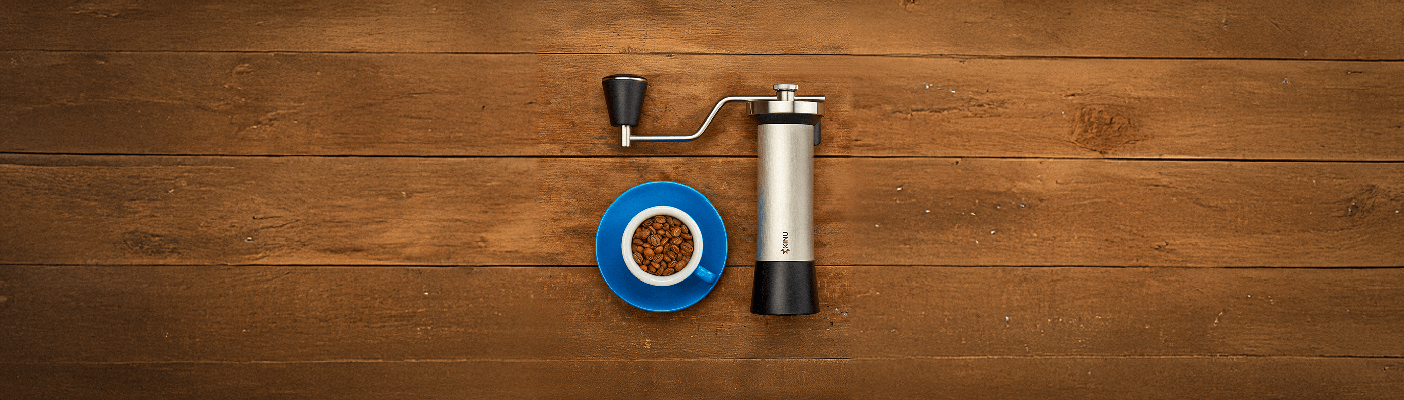 Coffee grinder next to a blue cup of coffee beans, perfect for coffee lovers and drinkware in Dubai, UAE.