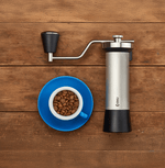 Professional coffee grinder with 47mm Black-Fusion conical burrs, smooth ball-bearing mechanism, stainless steel catch-cup, magnetic funnel, and EVA travel case for on-the-go brewing.