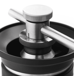 Kinu manual coffee grinder with 47mm Black-Fusion conical burrs, smooth ball-bearing mechanism, and EVA travel case, engineered for speed, precision, and portability.
