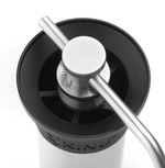 Kinu manual coffee grinder with 47mm Black-Fusion conical burrs, smooth ball-bearing mechanism, and EVA travel case, engineered for speed, precision, and portability.