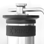 Kinu manual coffee grinder with 47mm Black-Fusion conical burrs, smooth ball-bearing mechanism, and EVA travel case, engineered for speed, precision, and portability.
