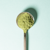 A silver spoon filled with vibrant green matcha powder, perfect for making Matcha Lemonade.