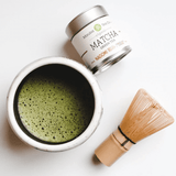 Nagomi Ceremonial Grade Organic Matcha Green Tea in a bowl with a bamboo whisk and tin.