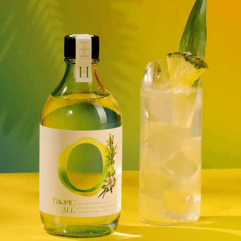 Tropic All 0.00% ABV botanical drink bottle with glass, highlighting Caribbean flavors and rum-like taste.