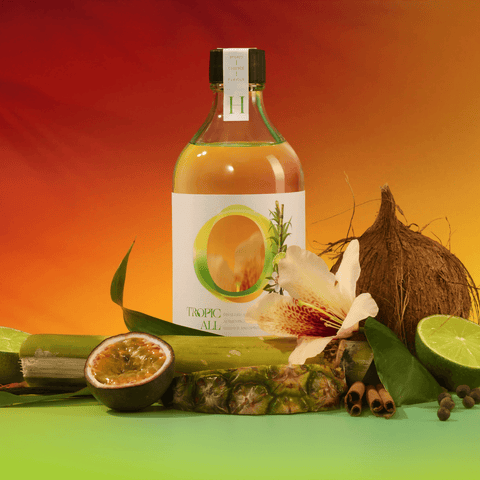 Tropic All botanical drink bottle amidst Caribbean flavors like lime, nutmeg, and sugar cane with a vibrant tropical background.