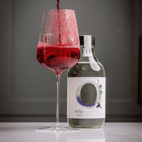 Herb All botanical drink with red cocktail in a glass, highlighting sophisticated non-alcoholic beverage options.