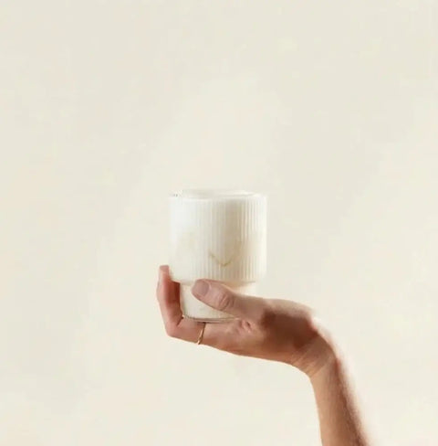 Tremella Mushroom Powder in a ribbed jar held by hand, hydrating mushroom supplement for dewy skin