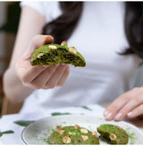 Emerald Matcha green tea cookie held in hand, ceremonial-grade vibrant matcha dessert with smooth umami flavor