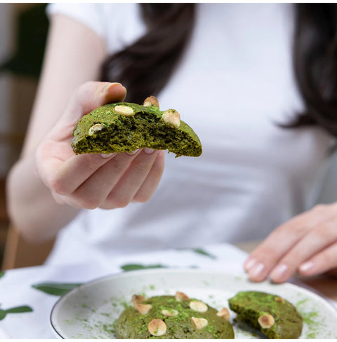 Emerald Matcha green tea cookie held in hand, ceremonial-grade vibrant matcha dessert with smooth umami flavor