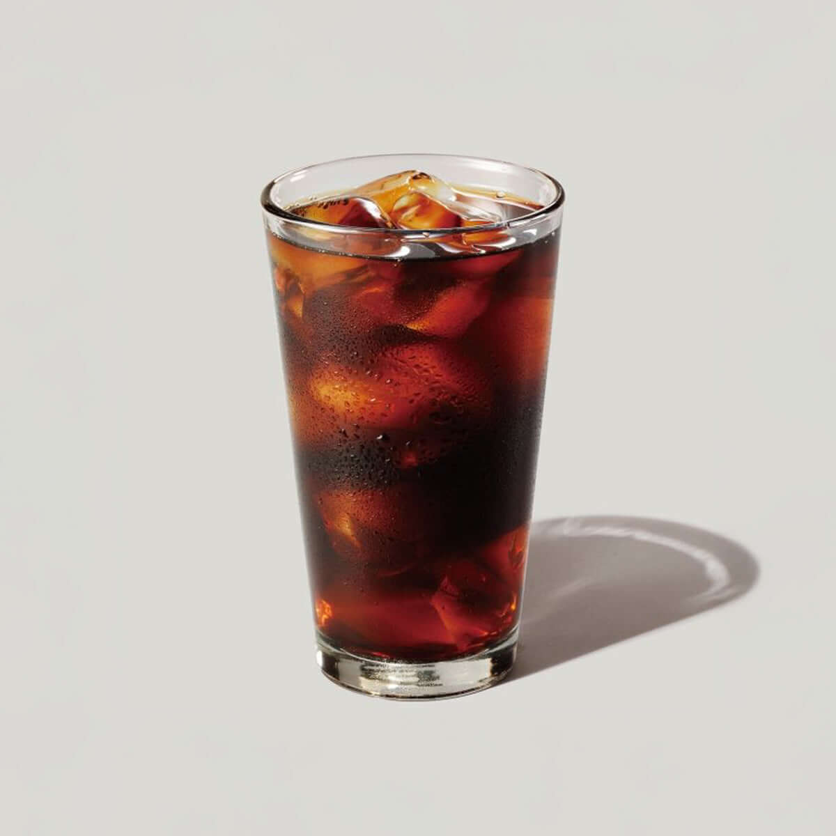 Glass of cold brew coffee with ice, showcasing rich color and refreshing appearance, perfect for a premium coffee experience.