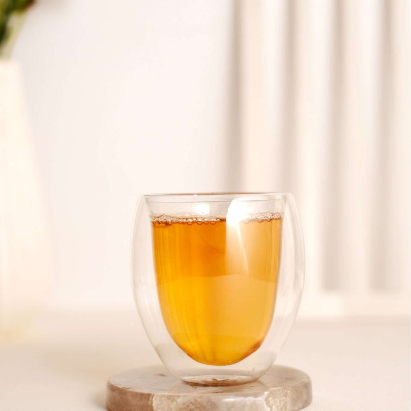 Glass of brewed Organic North African Peppermint leaves tea on a marble coaster