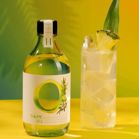 Tropic All 0.00% ABV botanical drink bottle with glass, highlighting Caribbean flavors and rum-like taste.