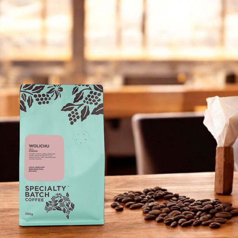 Wolichu specialty batch coffee package on a wooden table with coffee beans.